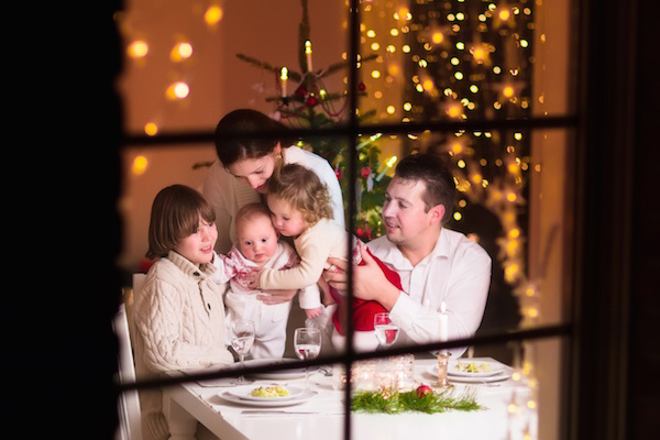 Postal navideña de una familia a través de la ventana