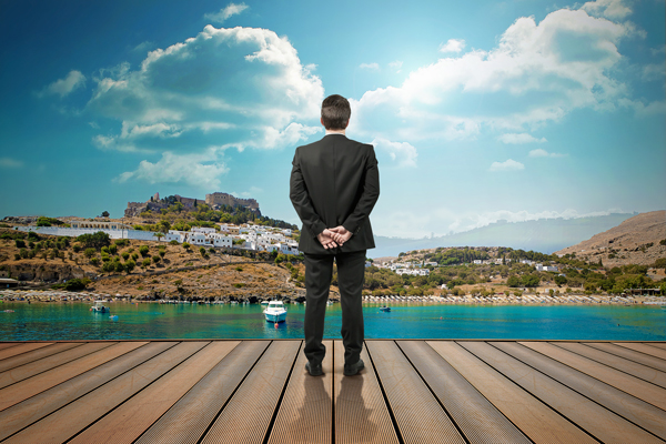 Hombre vestido de traje mirando un escenario de vacaciones
